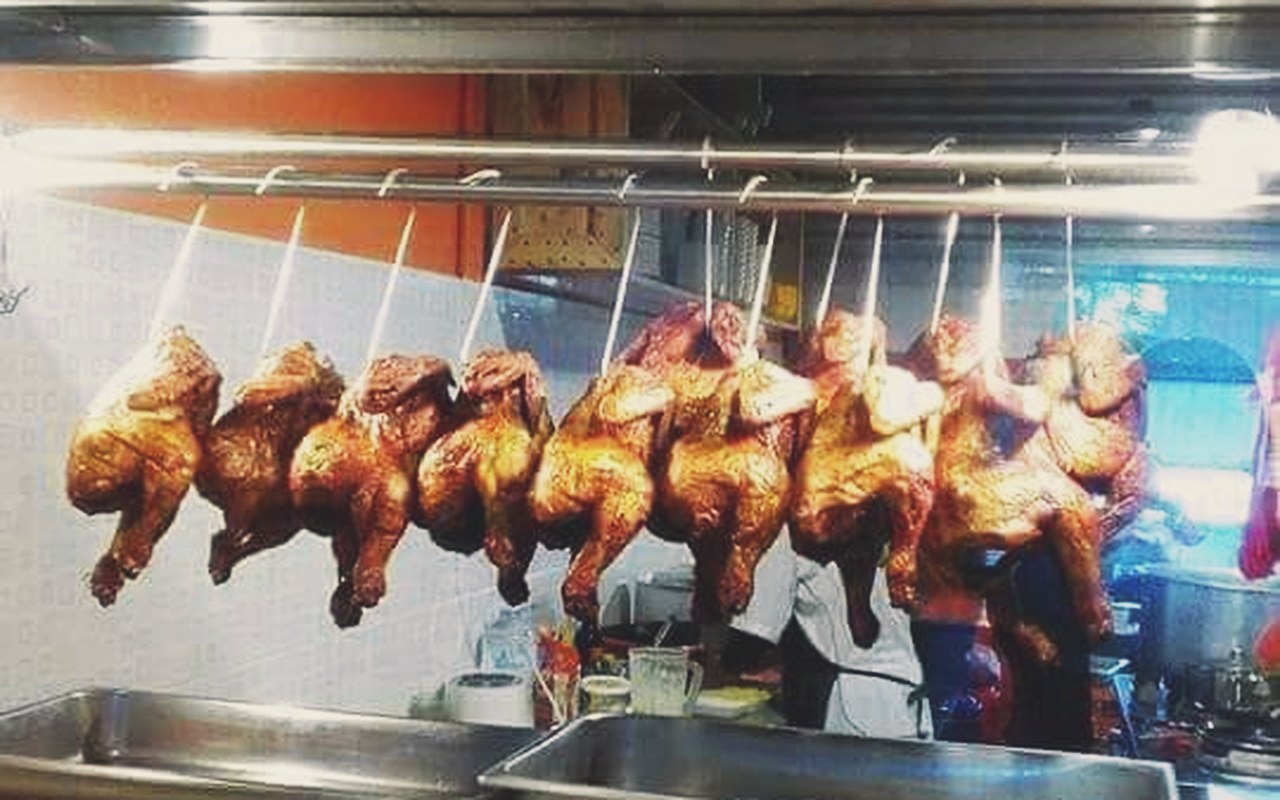 Nasi Ayam Baba Corner - Deretan ayam panggang madu berkilat yang digantung panas di kaunter pesanan.