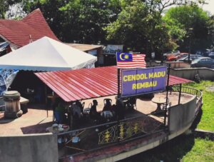 Papan Tanda Rasmi Cendol Madu Rembau dengan Ruang Makan Santai Tepi Sungai