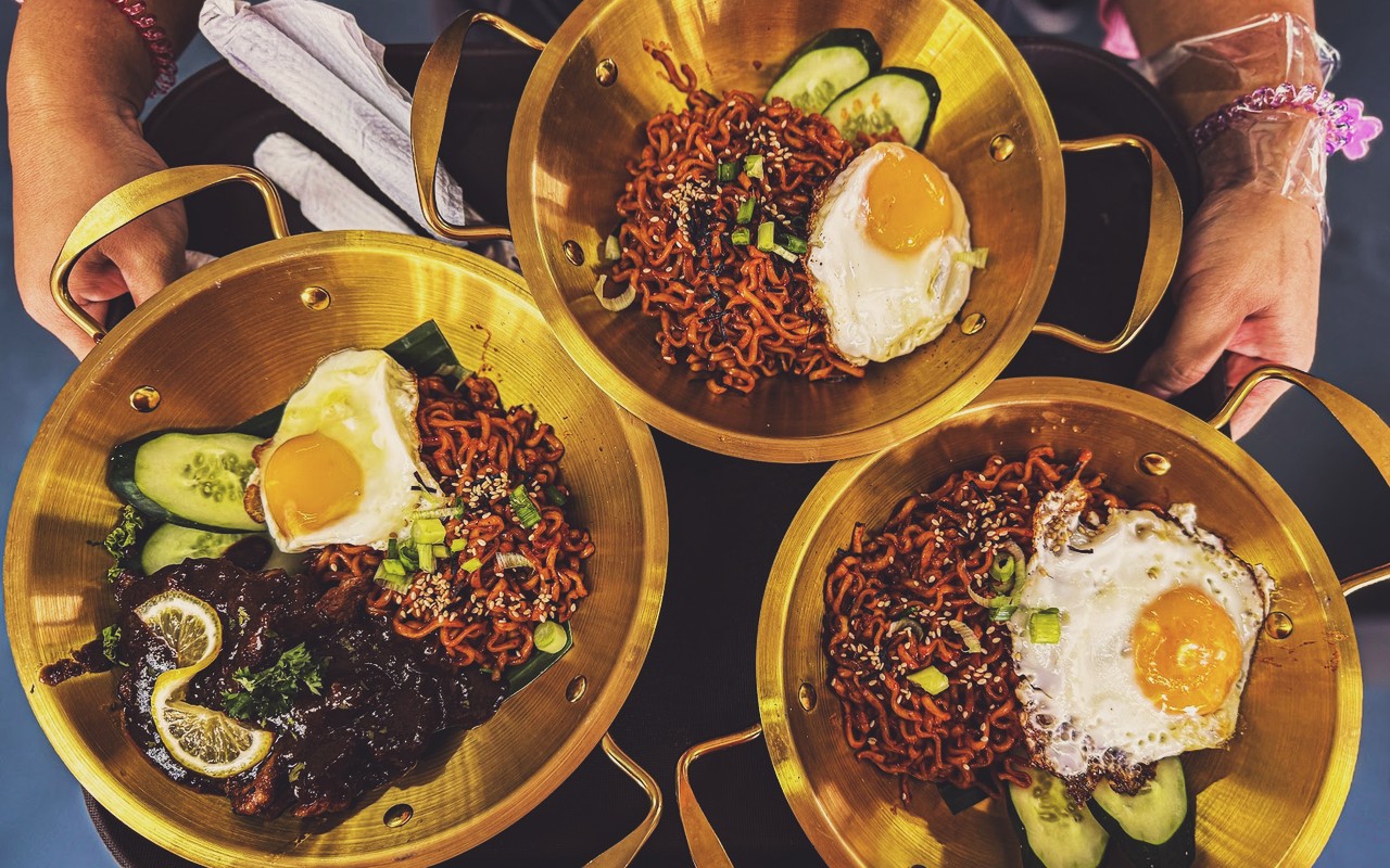 Hide Or Out Cafe & Space (H2O Tampin) - Mangkuk kuali emas sajian mi pedas ala Korea bersama telur mata goyang dan ulaman segar.
