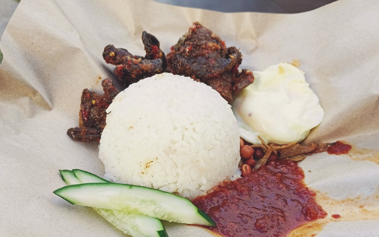 Laman Hijau Cafe Tampin - Bungkus nasi lemak tradisi beralaskan daun pisang wangi bersama sambal sotong pekat, telur rebus dan timun rangup.